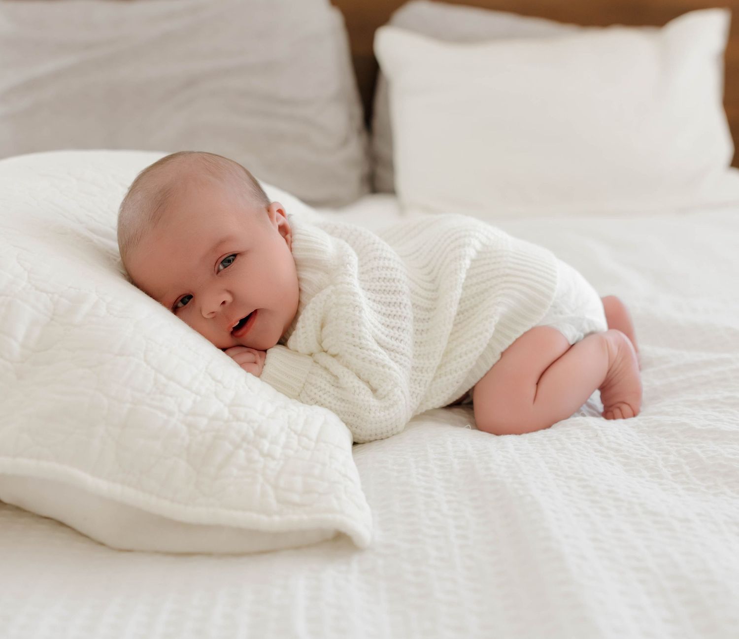 Peaceful sleeping newborn swaddled in white blanket on cozy bed.