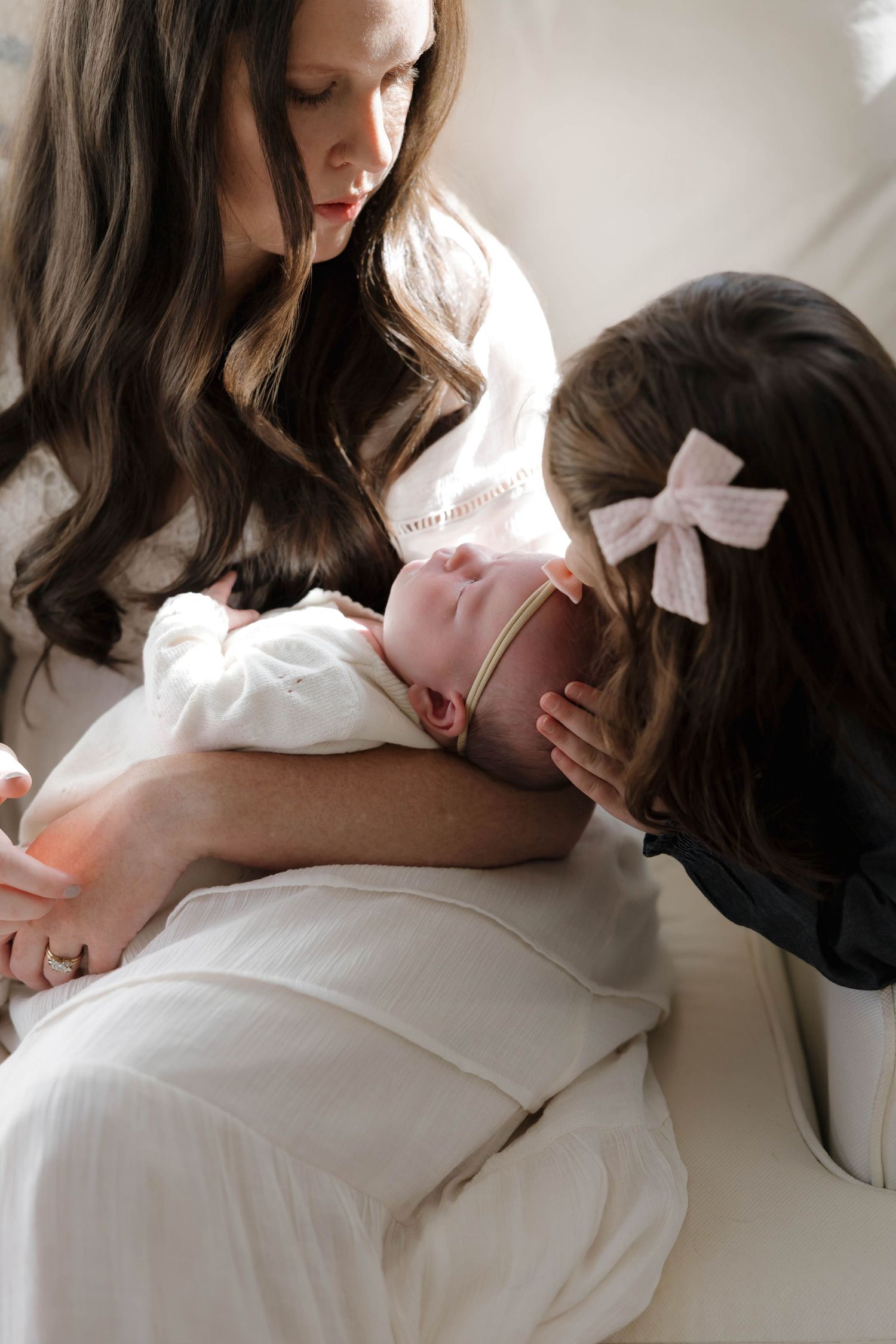 A series of intimate breastfeeding moments showing mother and baby bonding in soft, natural light against white bedding.