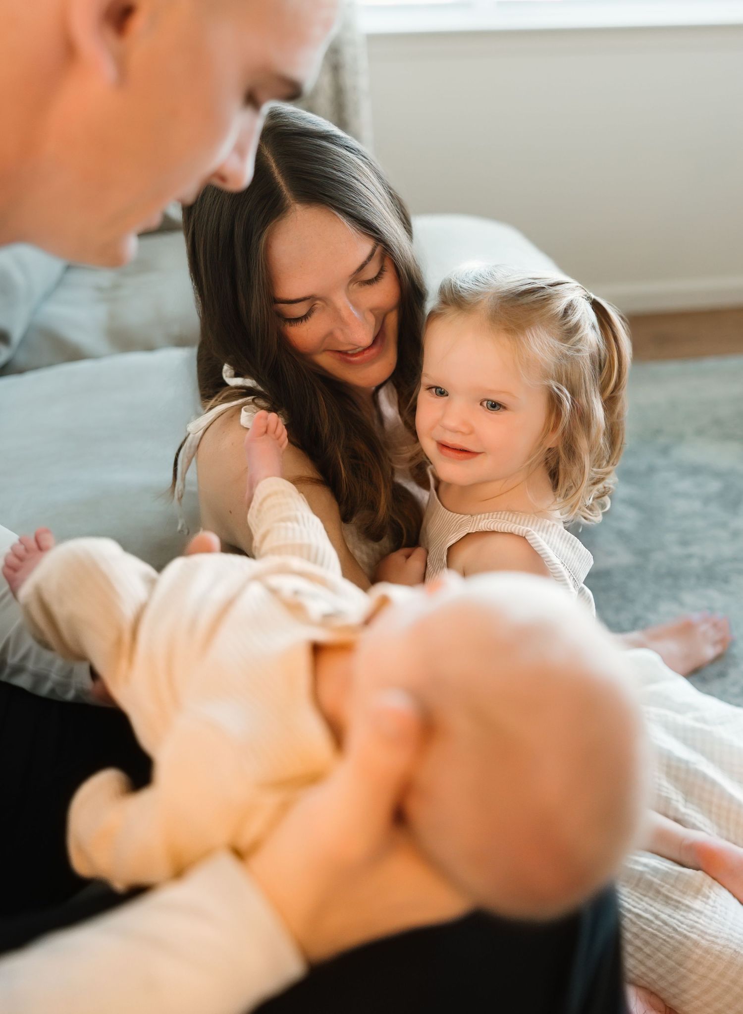 Tender family moment captured in a bright, airy setting showing loving interaction and gentle embraces.