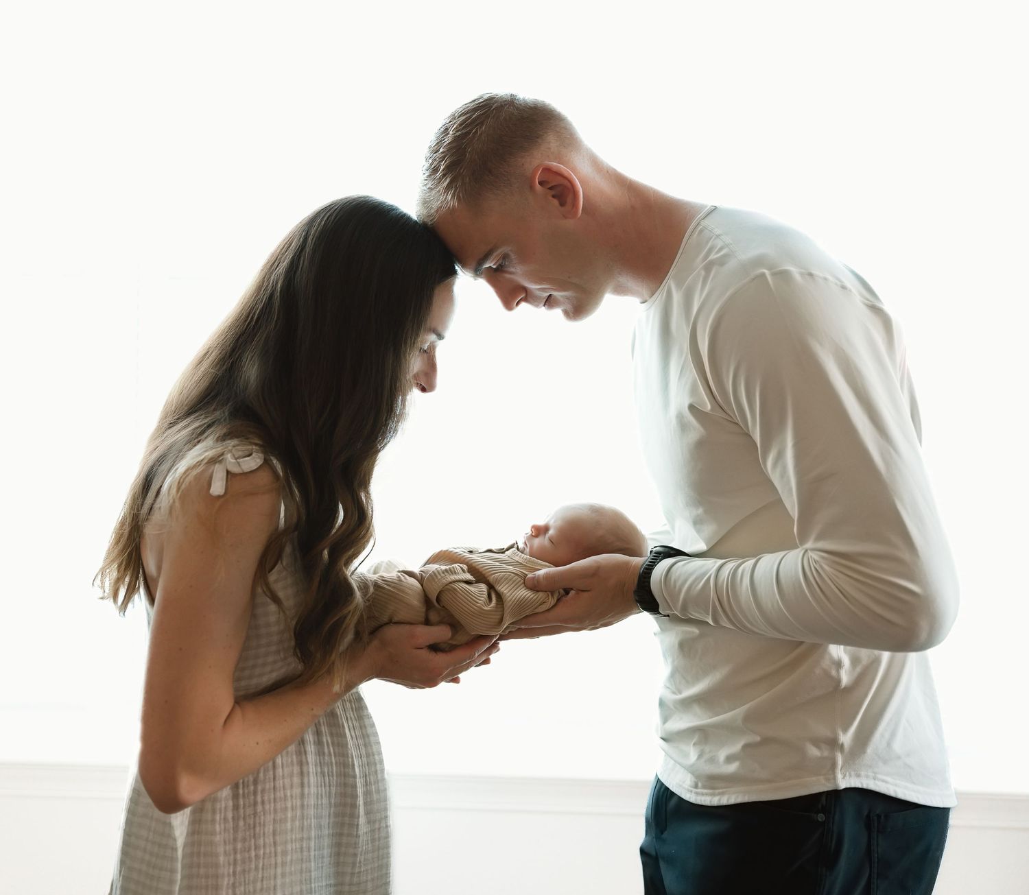 A couple in white clothing leans together intimately in a bright indoor setting with multiple similar poses.