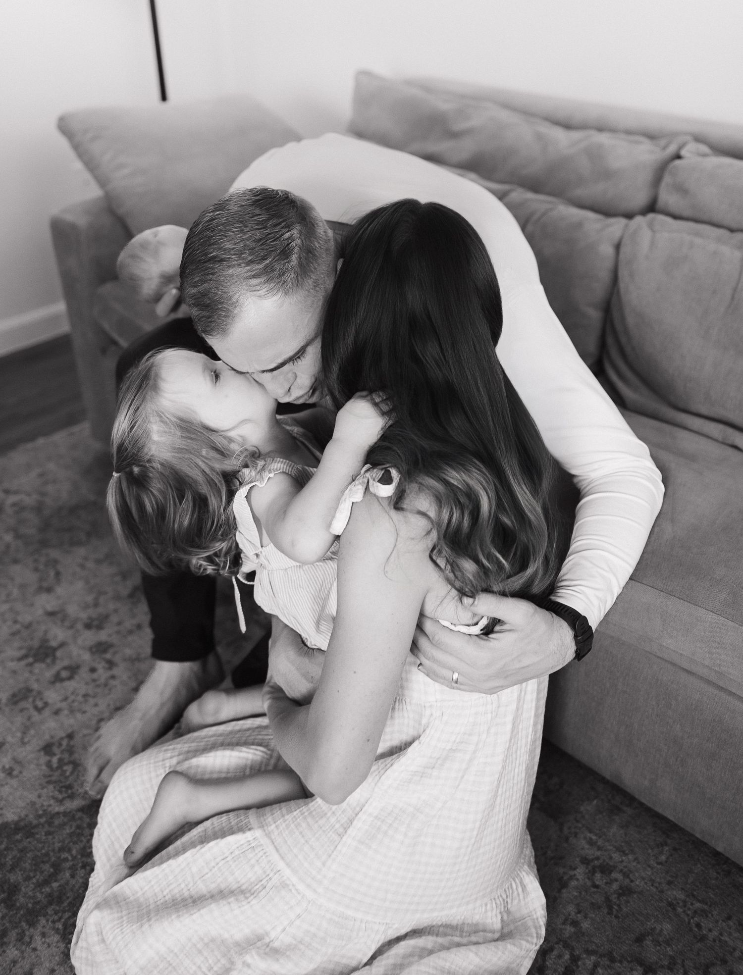 A series of black and white photos showing tender moments between parent and child on a couch.