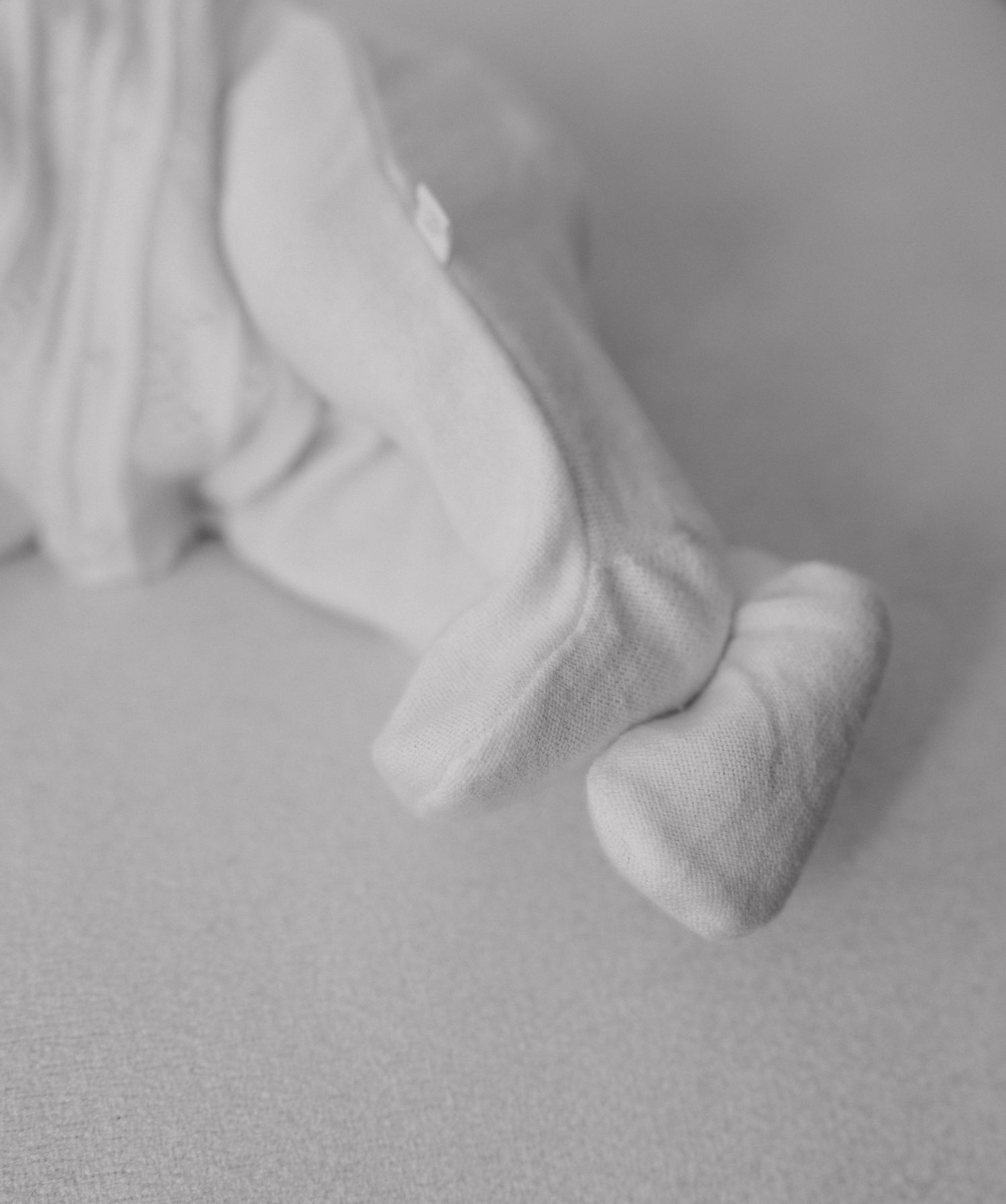 A series of minimalist black and white photographs showing close-up details of soft fabric folds and textures.