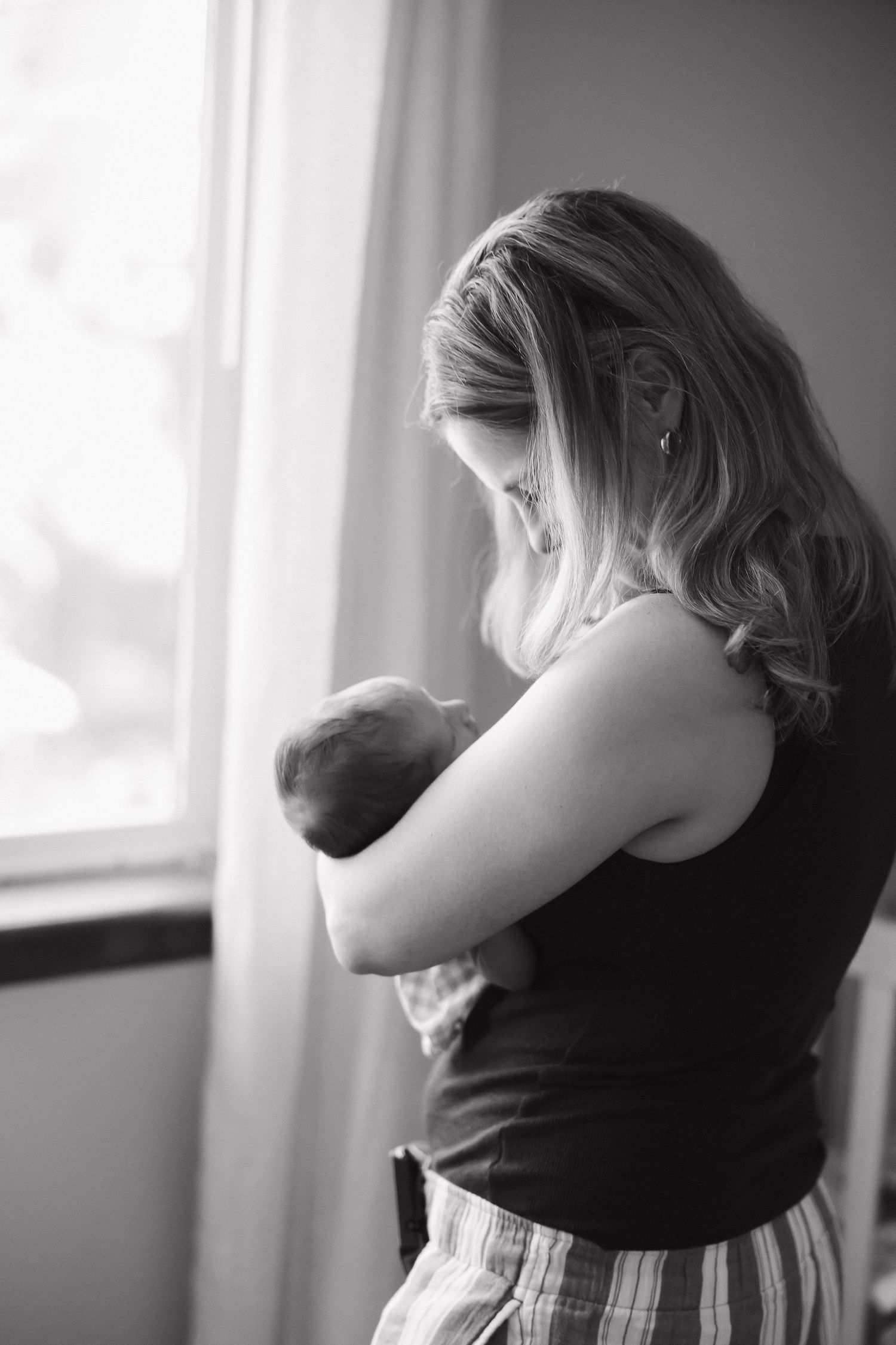 Black and white artistic photo series showing woman in profile looking out window with contemplative expression.