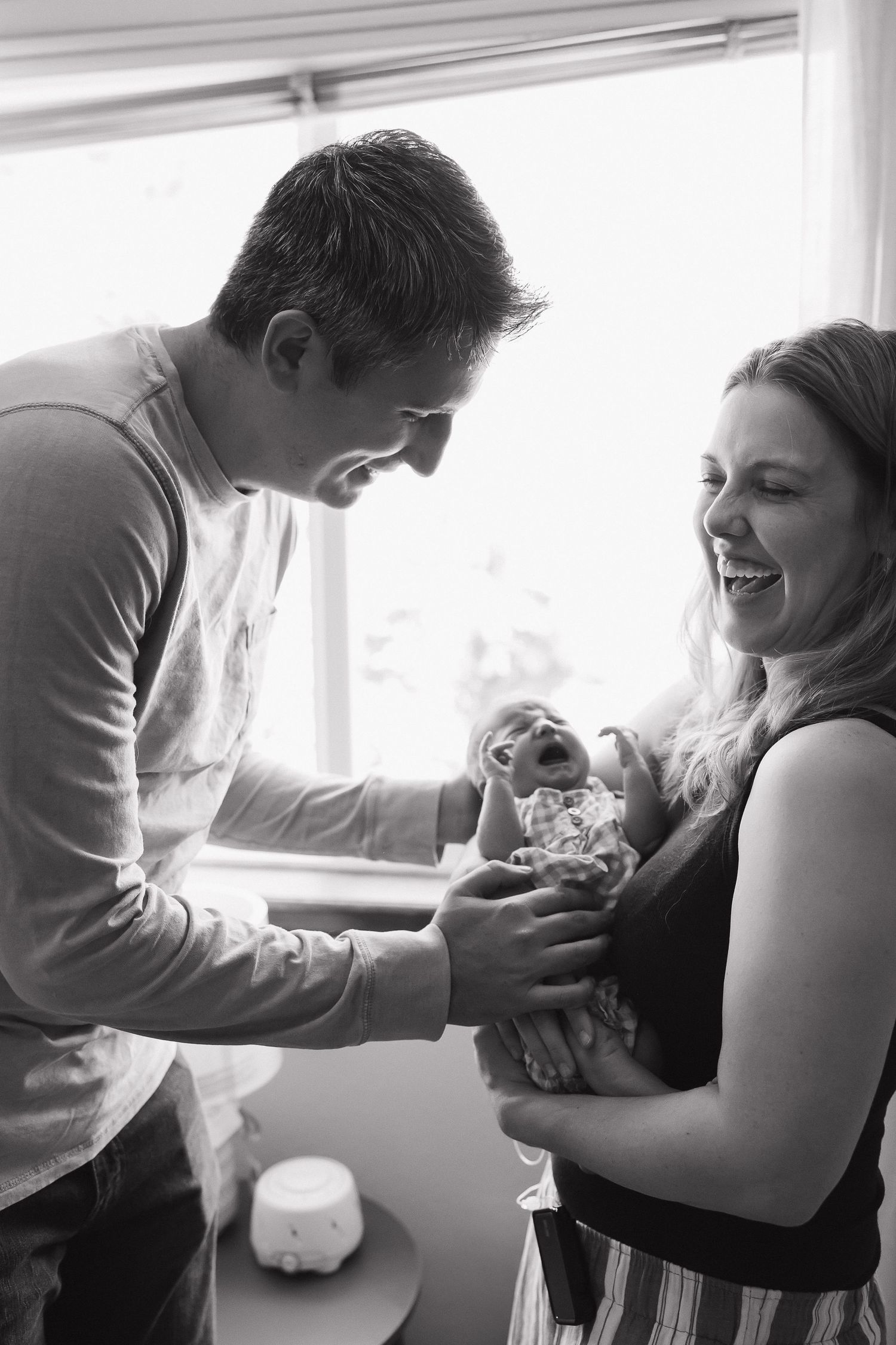 Progressive sequence showing a tender moment between a parent and newborn in a bright hospital room.