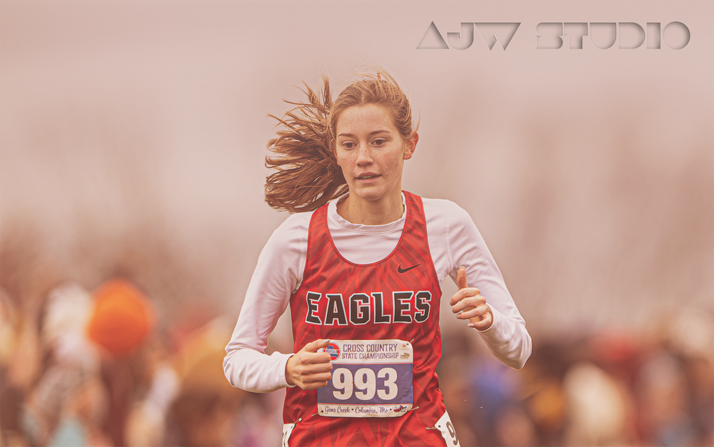 Cross country runner wearing red Eagles jersey competes in a race.