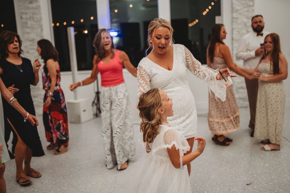 Celebratory dancing at a wedding reception with guests in festive attire.