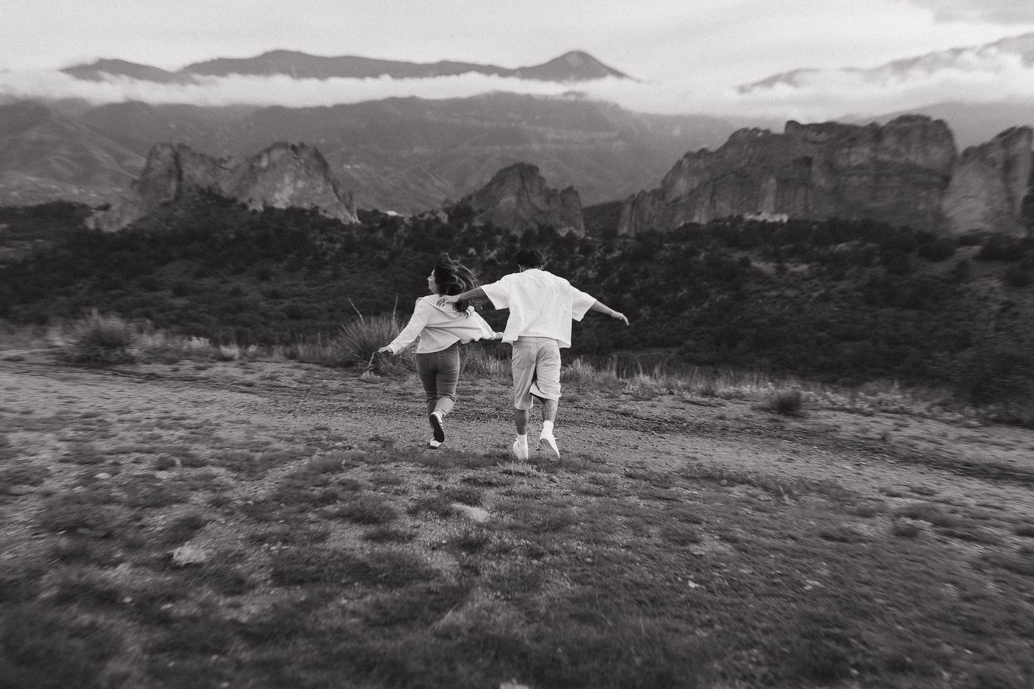 Two people holding hands together in an intimate black and white portrait. Colorado Springs Photographer.