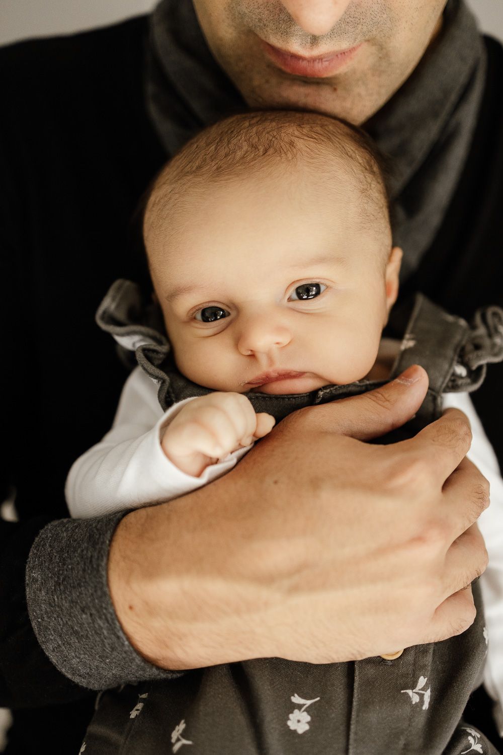 Dad holds new baby at in-home lifestyle photo session with Bay Area Newborn Photographer Cindy Tucey in Los Gatos