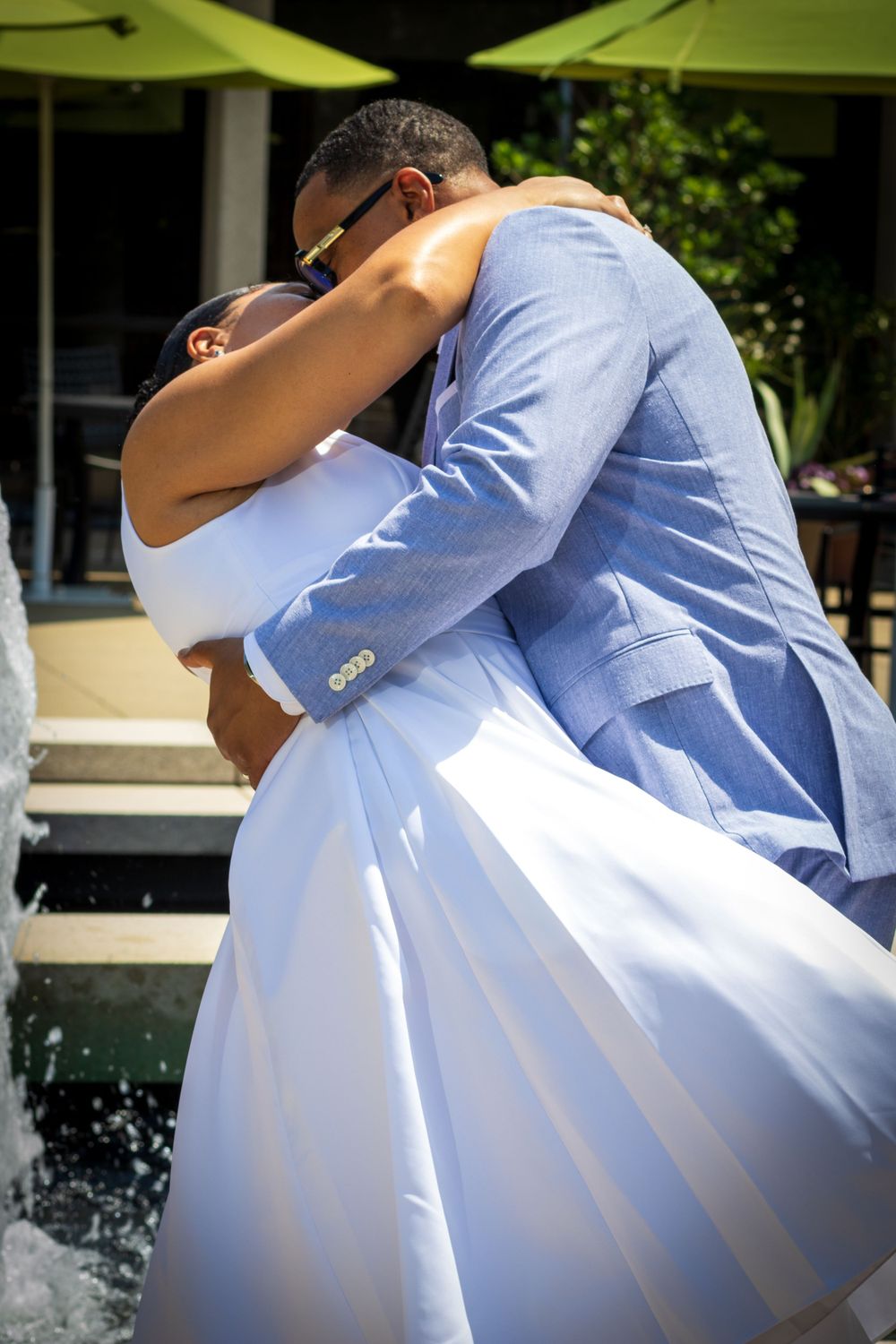 A bride and groom sharing a romantic dip and kiss outdoors, showcasing vibrant wedding photography by Empax Studios.