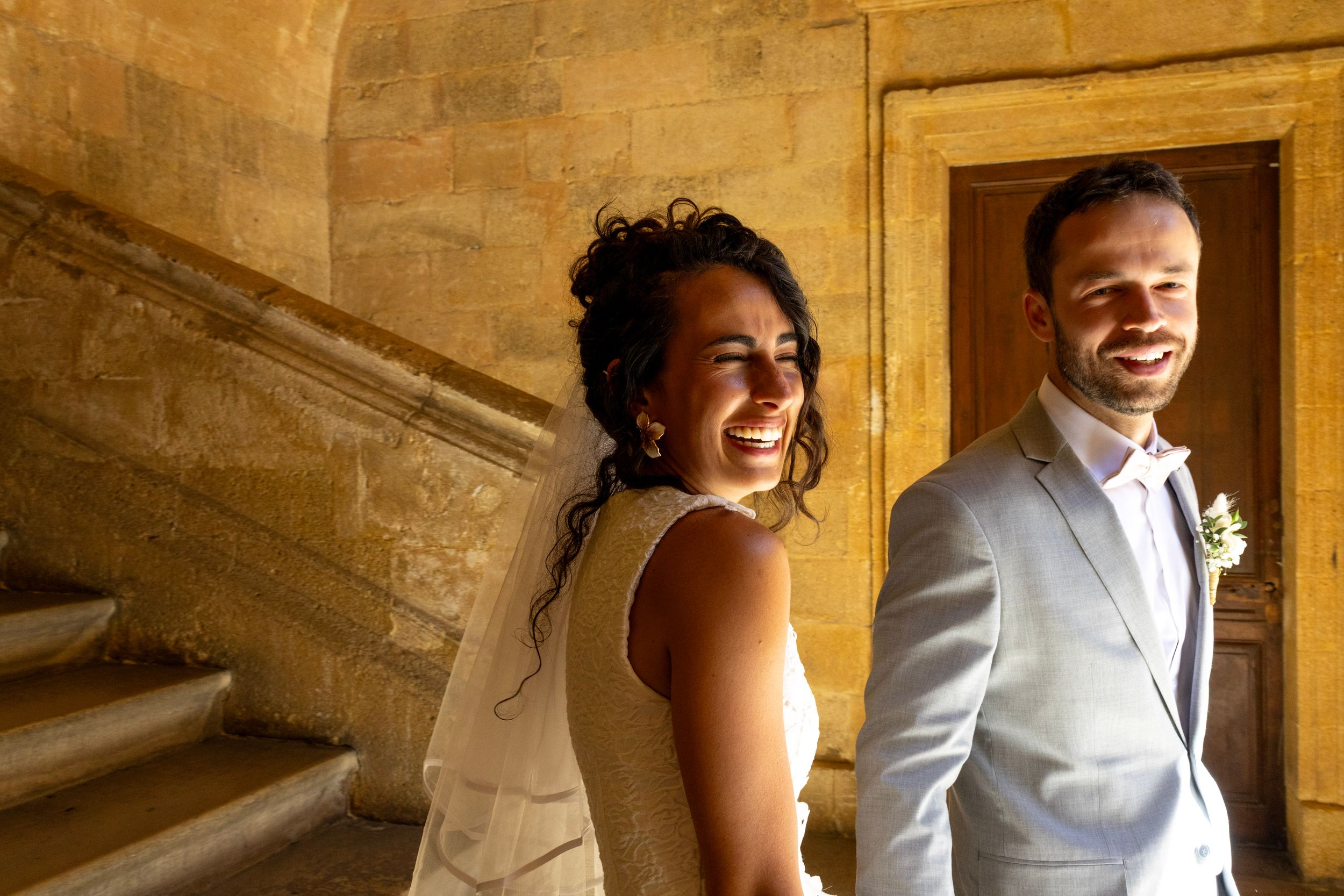 Les mariés sourient près d’un escalier en pierre lors de notre reportage à Aix-en-Provence