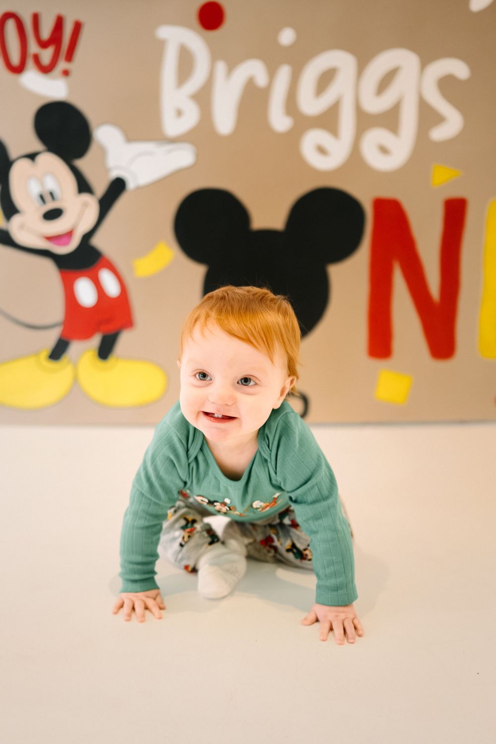 Milestone birthday portrait of a little boy turning one with themed decorations.