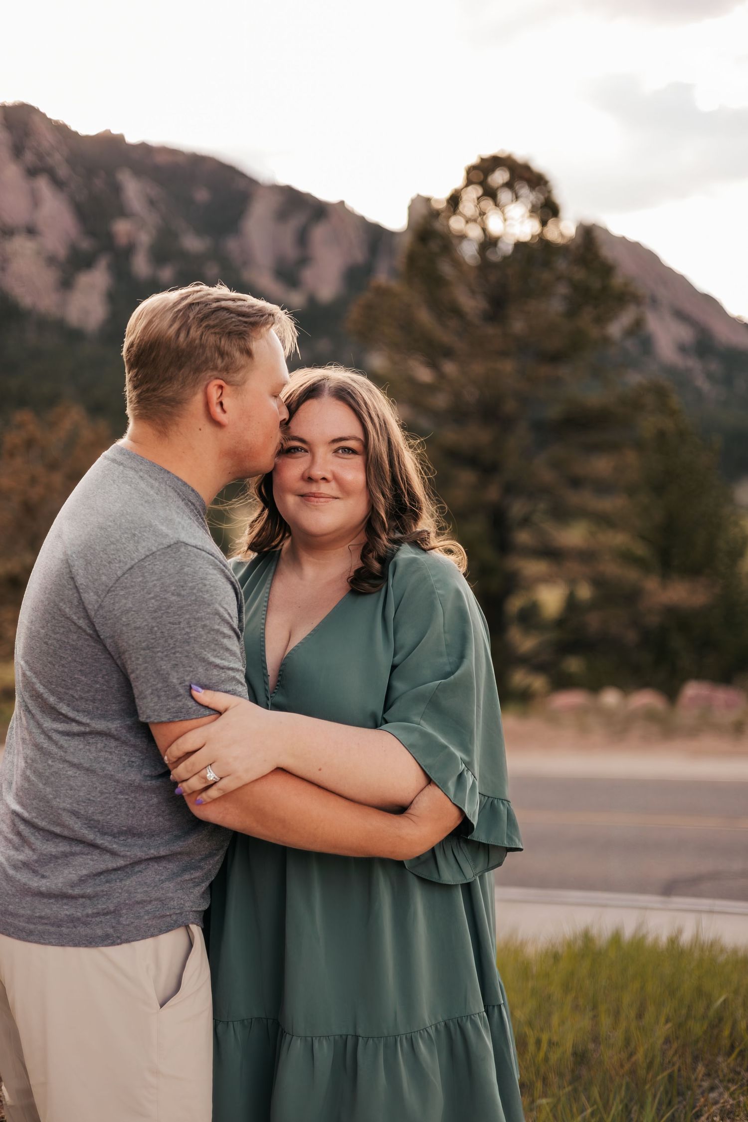 Couple embracing outdoors with Rocky Mountain backdrop|  Baby Announcement Photographer in Boulder, Colorado