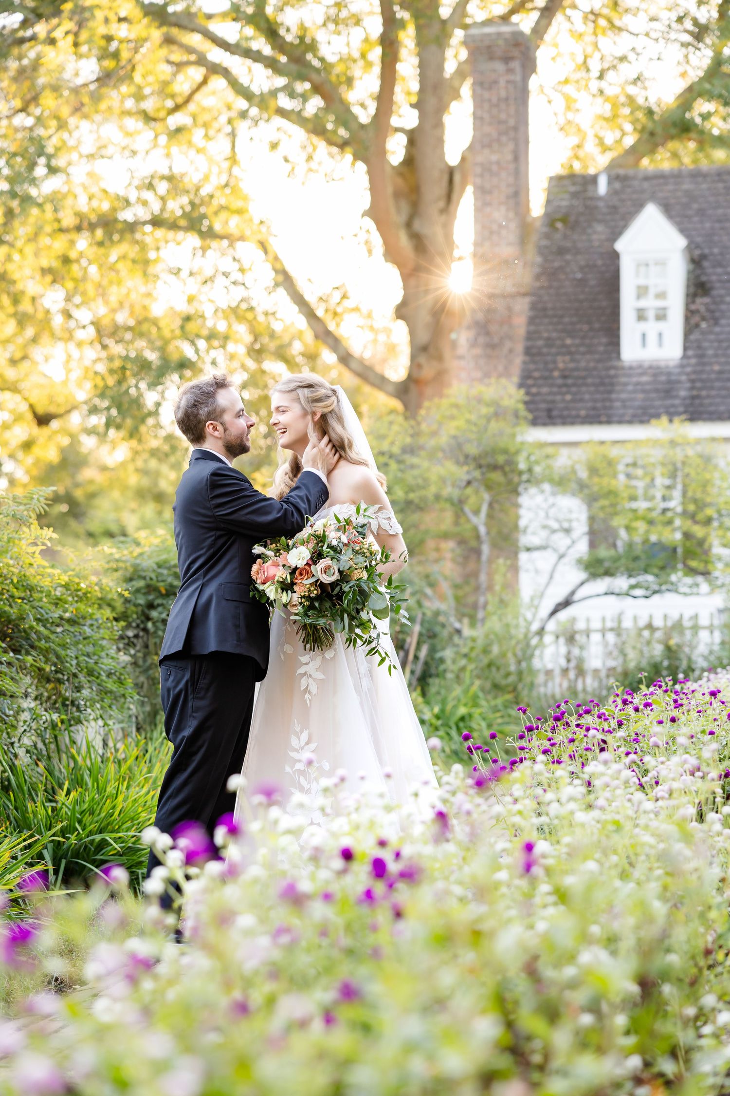 Photograph of beautiful bride and groom embracing in a flowery cottage garden in Colonial Williamsburg following their formal wedding.