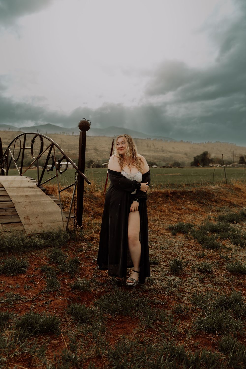 Woman stands and poses in field for dramatic, cinematic, portrait, and modeling photos in Fort Collins, Colorado