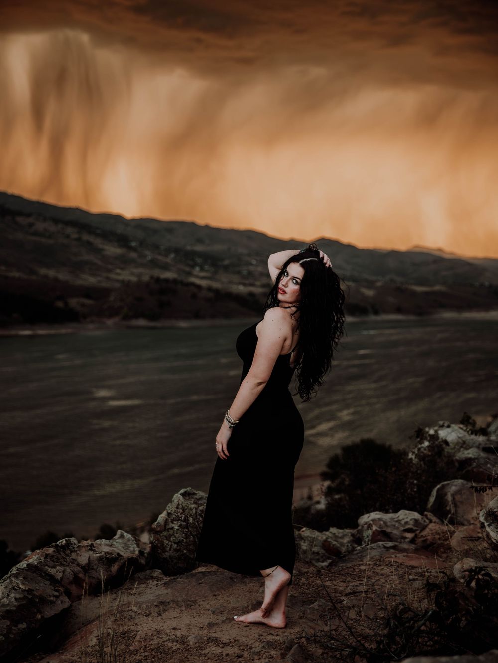 Woman poses in front of dramatic, cinematic sky for portrait and modeling photos in Fort Collins, Colorado