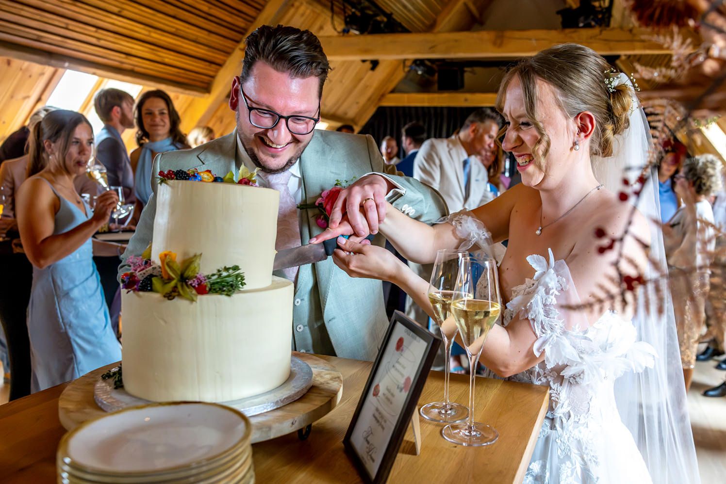 Vrolijk moment bij het aansnijden van de bruidstaart van The Sweetlab tijdens de bruiloft van Donna en Twan