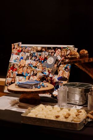 Wedding reception dessert table featuring photo collage display and assorted sweet treats.