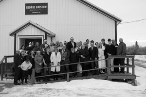 Large group photo of people gathered outside George Bristow building in winter, black and white photography.