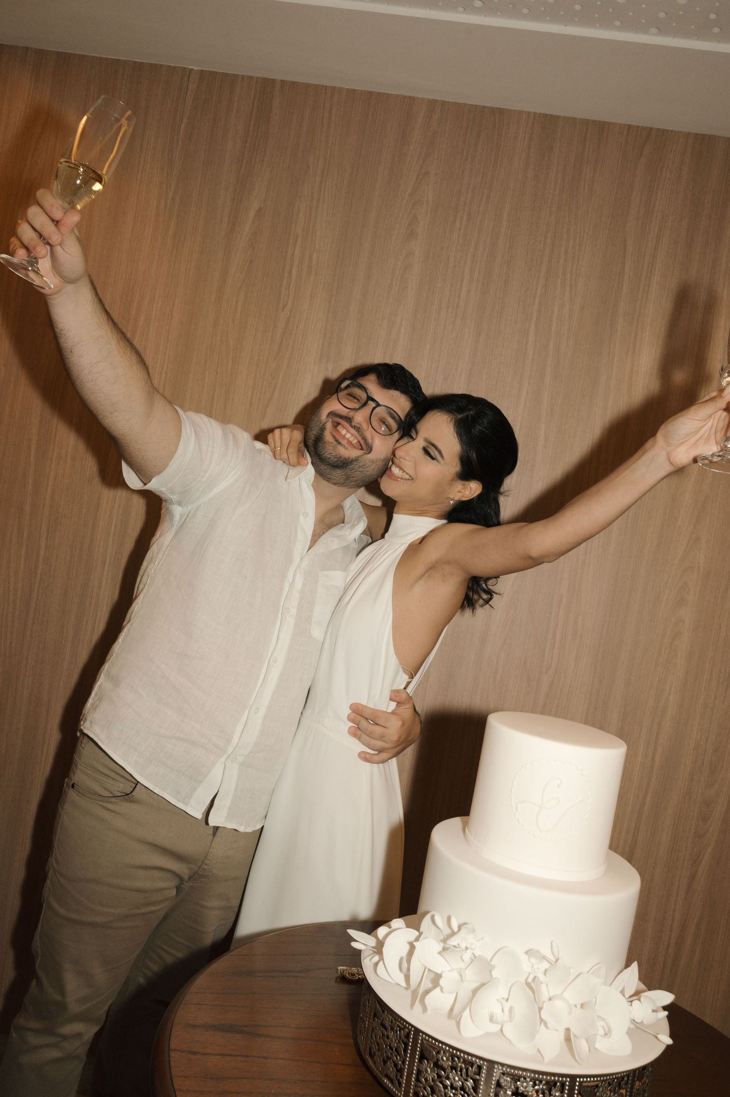 A romantic dance moment between a couple in white formal wear.