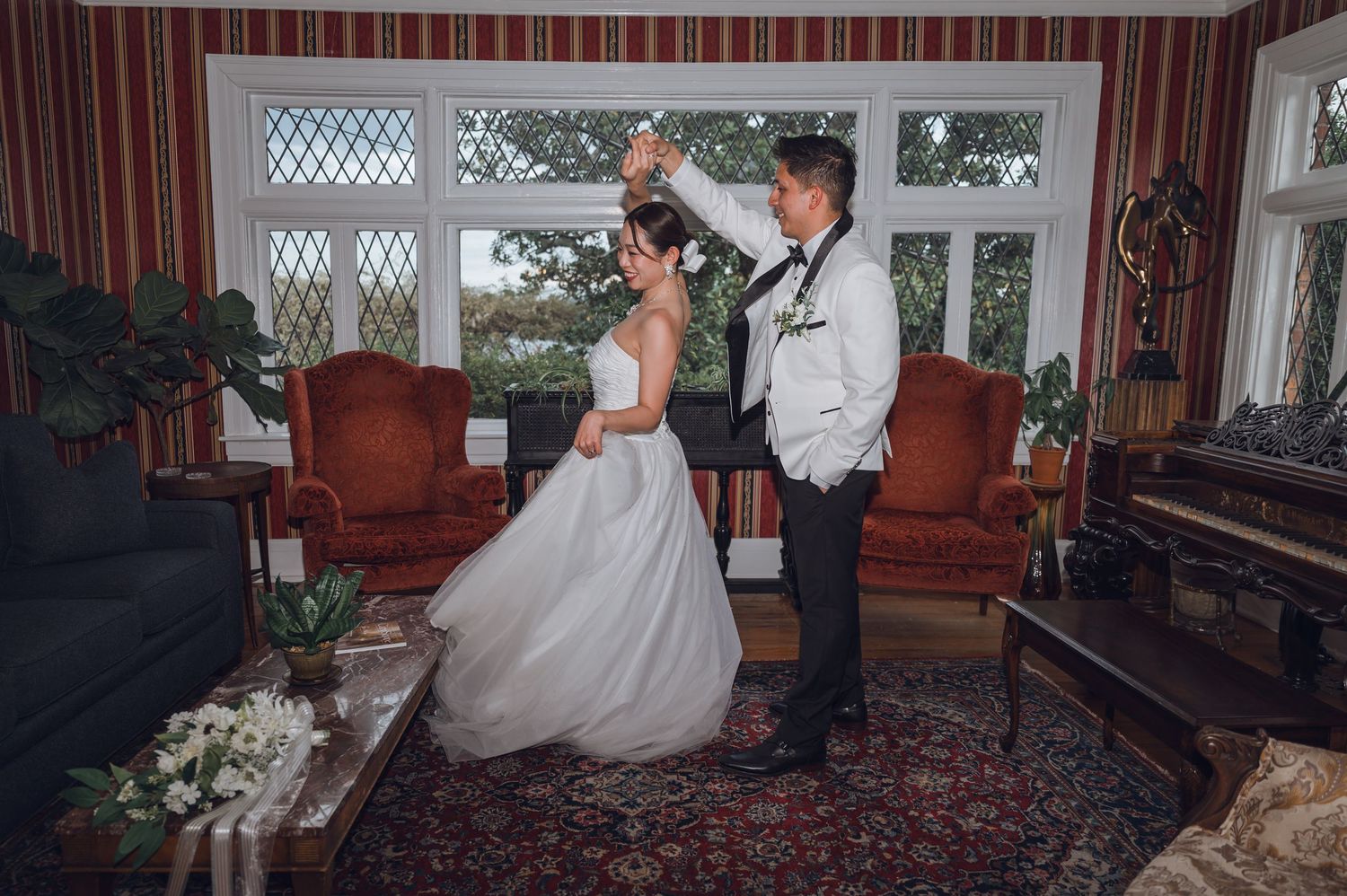 Bride and groom share a romantic dance in an elegant vintage living room during their wedding day.