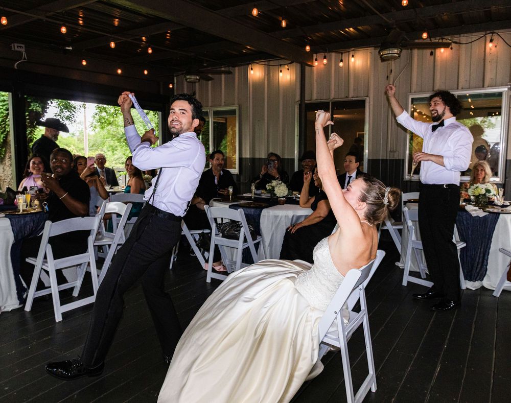 Bride and groom performing fun energetic wedding reception dance routine for guests at outdoor venue.