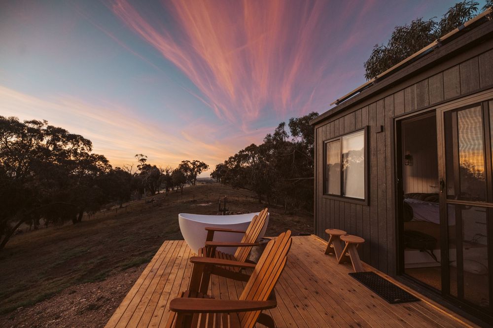 Boutique tiny home photography showcasing outdoor bath and sunset views across rural Victorian landscape