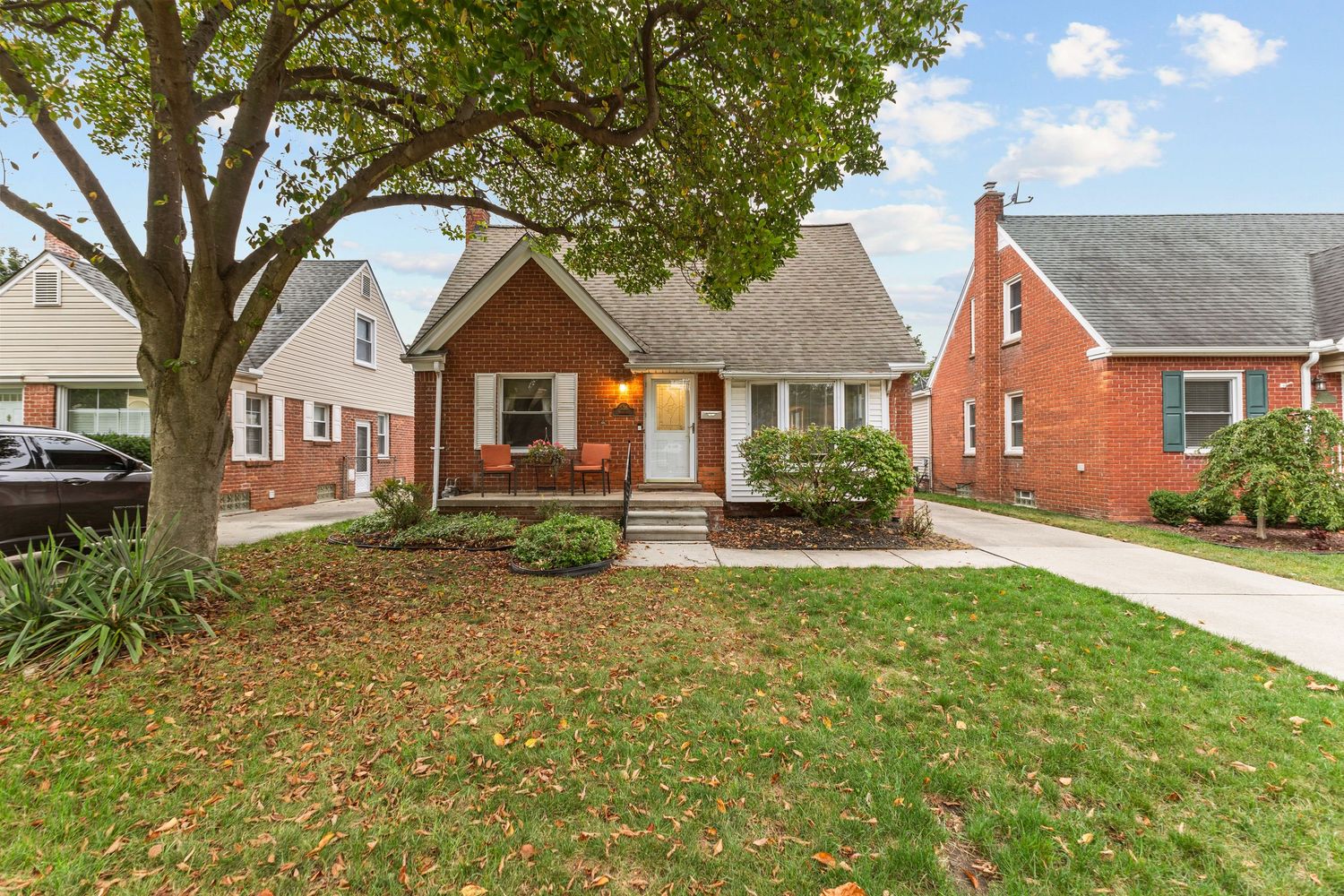 Two-story home with vinyl siding, covered front porch, attached garage, and well-maintained green lawn.