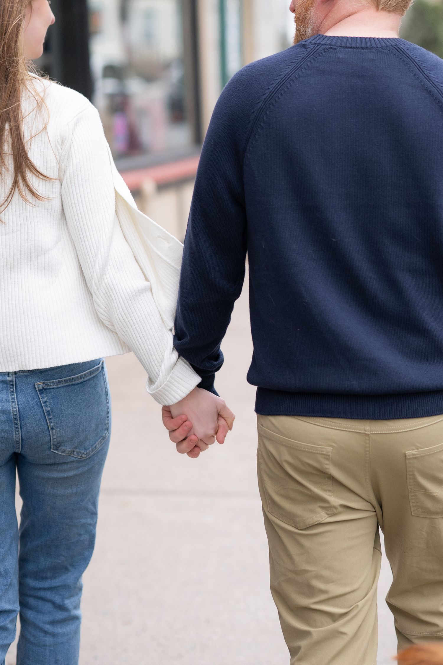 Engaged couple strolls through the hydro stone in Halifax holding hands