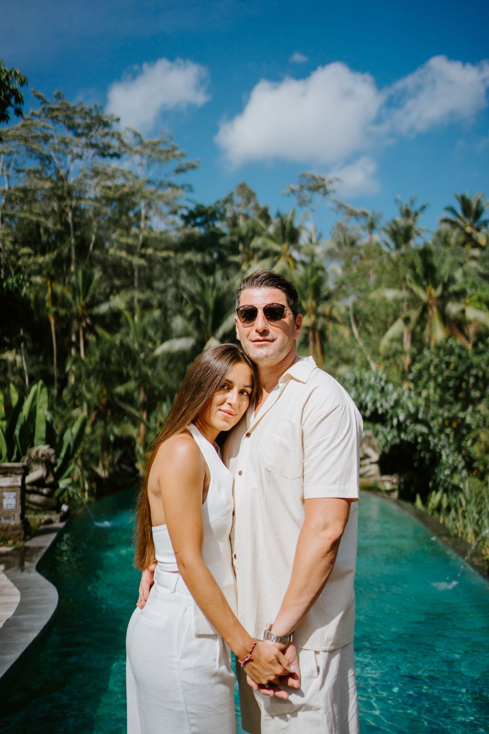 Romantic couple photos by infinity pool surrounded by tropical jungle landscape.