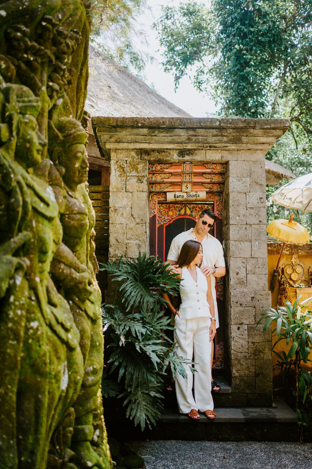 Romantic photo series in front of traditional stone architecture and tropical landscaping.