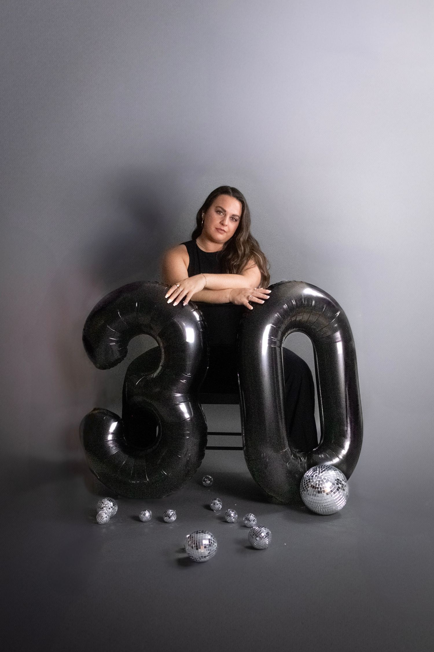 A creative photo series showing a person interacting with large black balloon letters spelling out SEO against a gray backdrop.