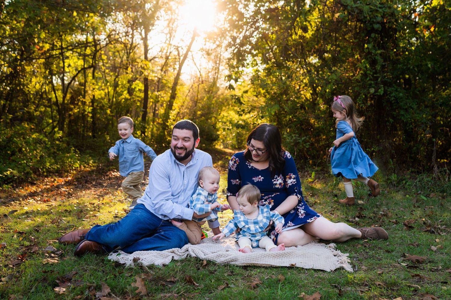 dallas outdoor fall family photos mom and dad holding infants while older kids run around them
