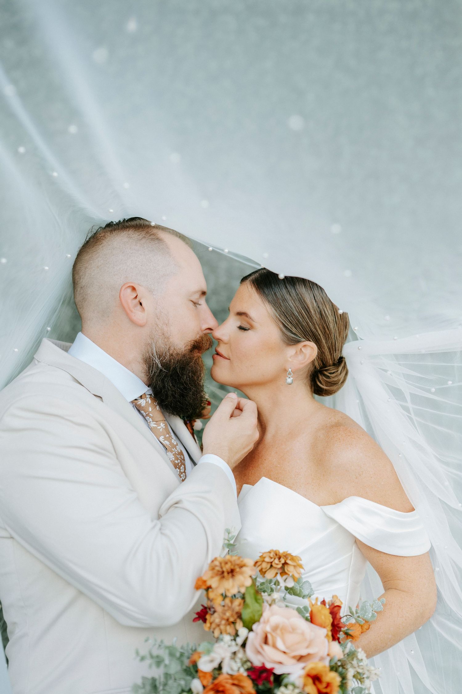 A romantic wedding photo series showing tender moments between newlyweds with a peach and white floral bouquet.