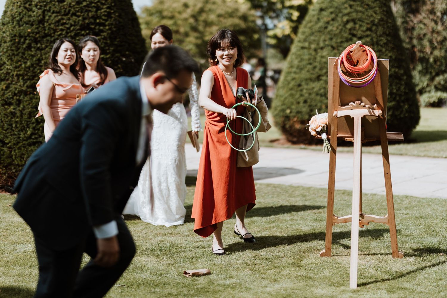 Well-dressed wedding guests play garden games  outdoor drinks reception at Rowton Castle.
