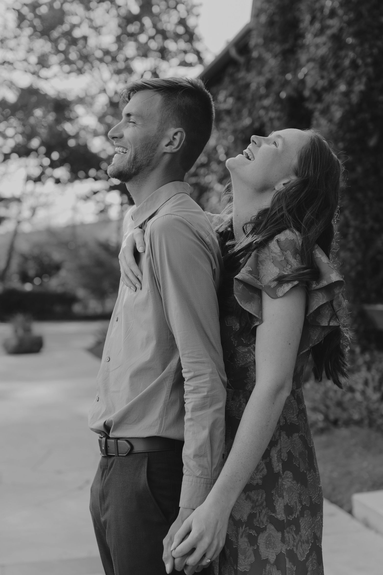 Black and white photo of a couple dancing together in a park setting.