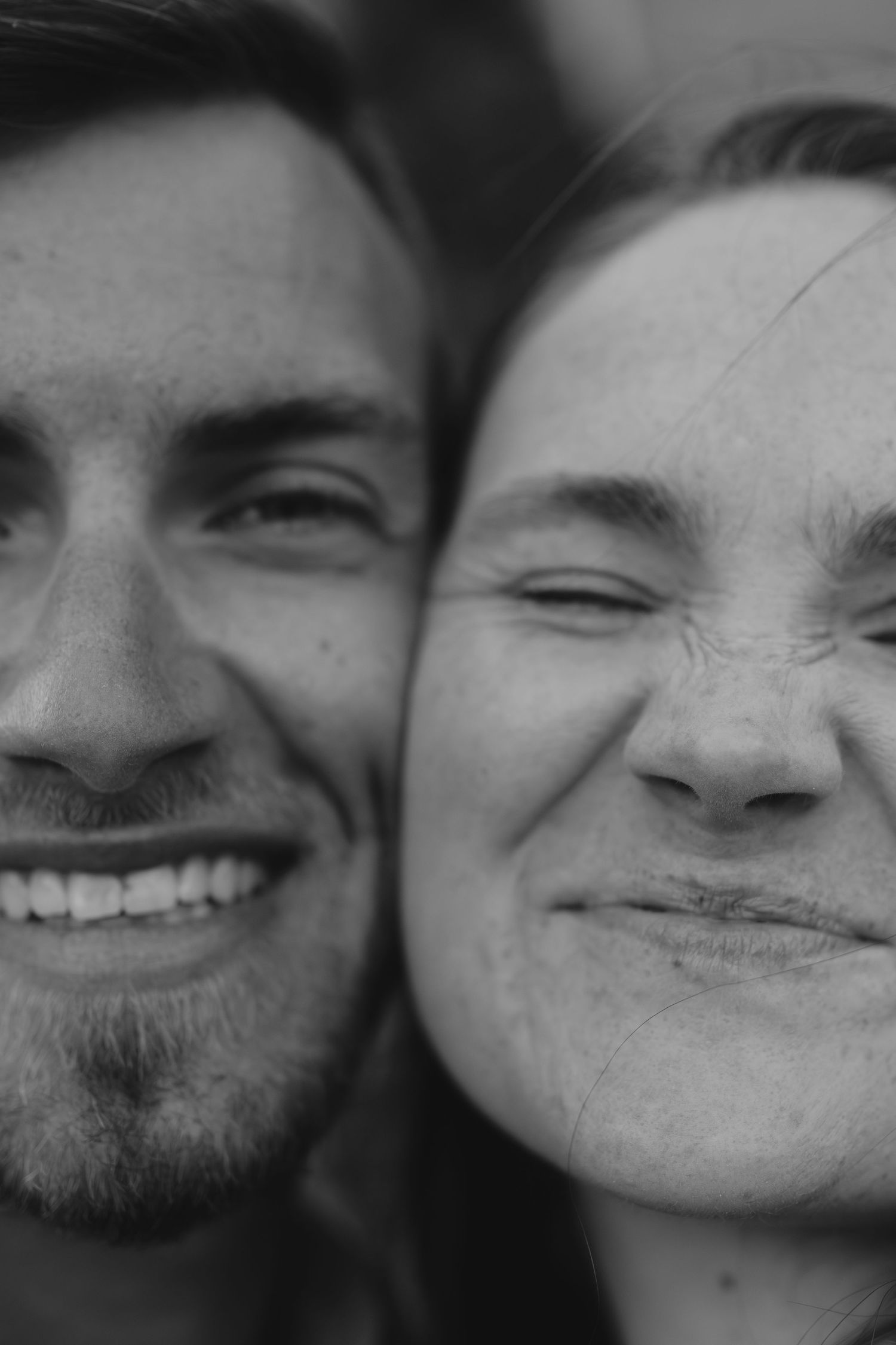 Close-up black and white portraits of a couple sharing intimate moments and smiles.