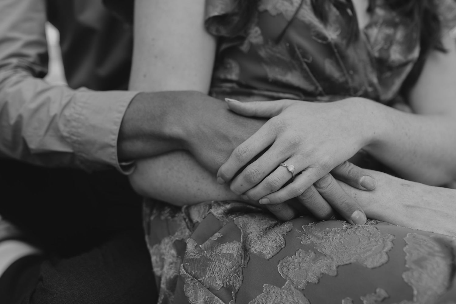 Detail shot of hands touching tenderly during an outdoor photoshoot.