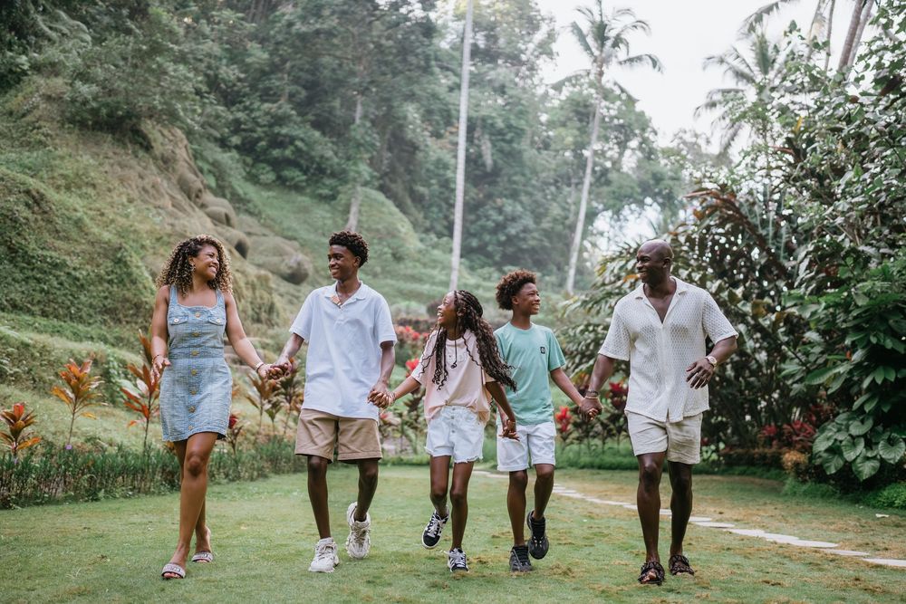 Group walking and laughing together on tropical hillside path.