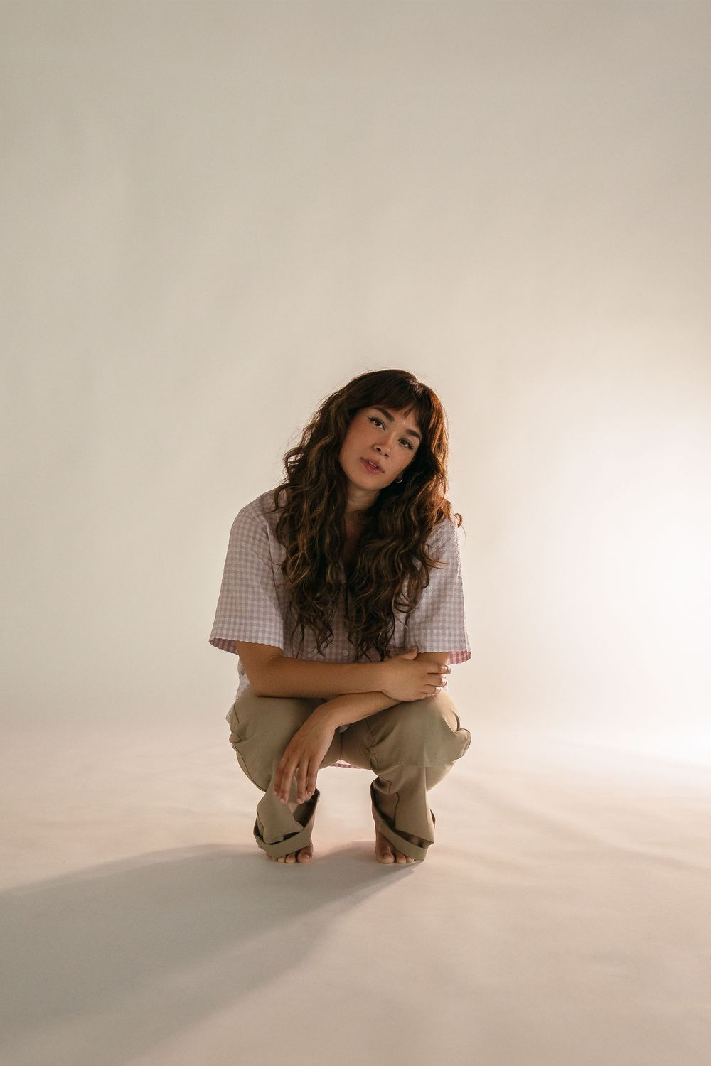 Minimalist studio photos showing casual poses against a white background.