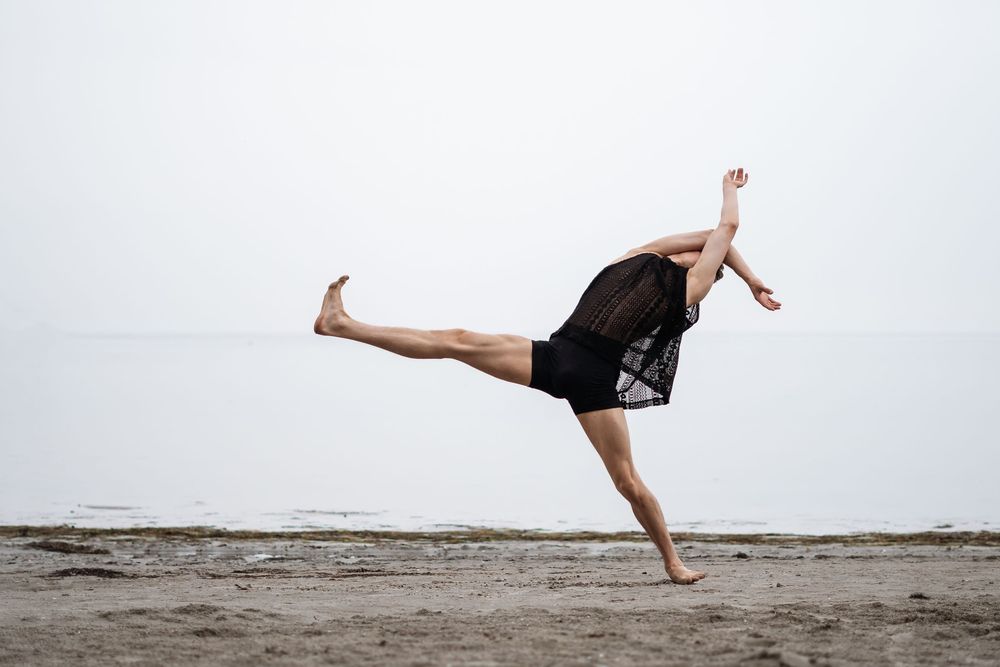 Minimalist dance movements captured against white background on beach.