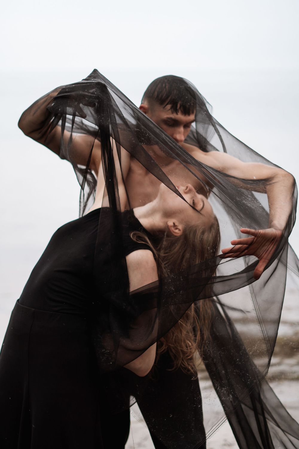 Artistic portrait sequence showing flowing black veil movement against light background.