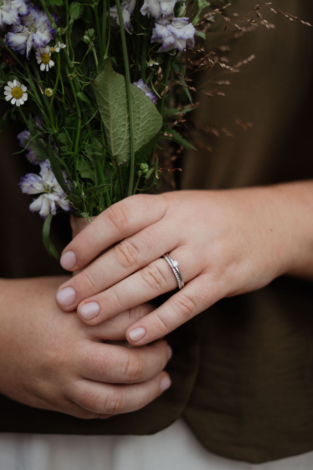 Close-up shots of hands holding delicate flowers with an engagement ring visible.