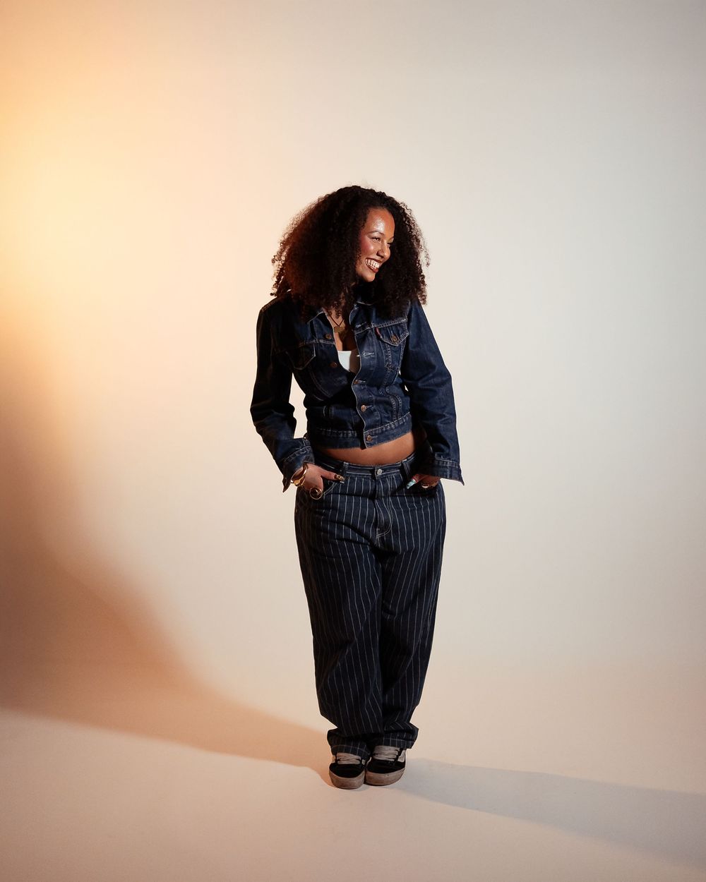 Fashion photo series showing pinstripe outfit poses against neutral background.