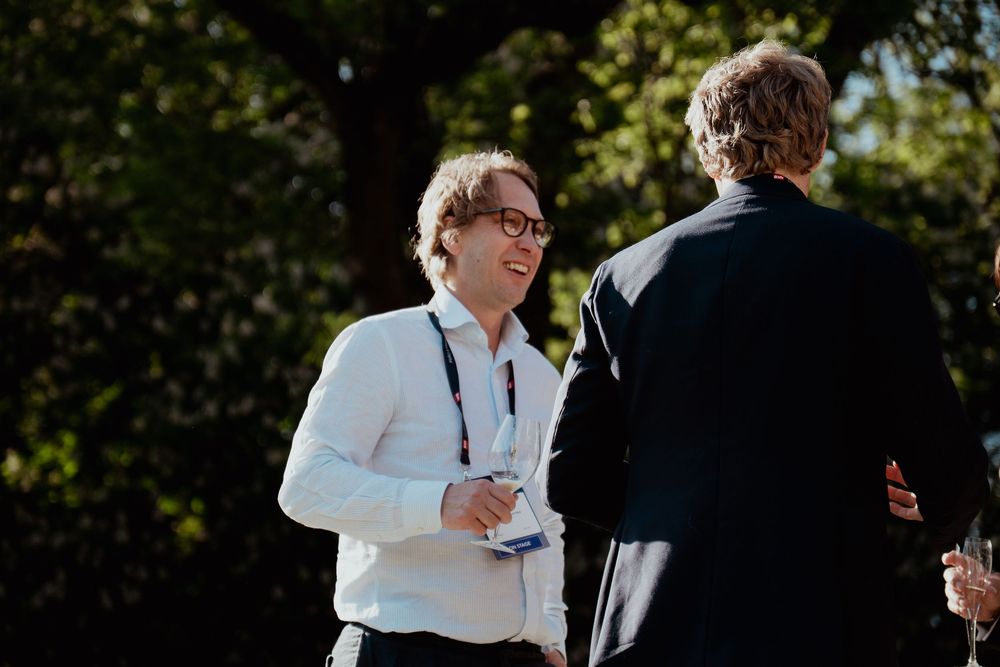 Outdoor gathering in natural lighting with people in formal attire.