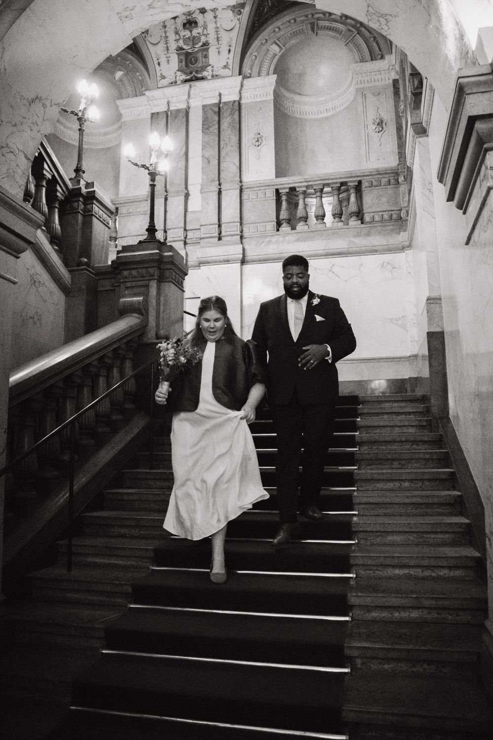 Black and white photos of a grand staircase in an elegant historic building.