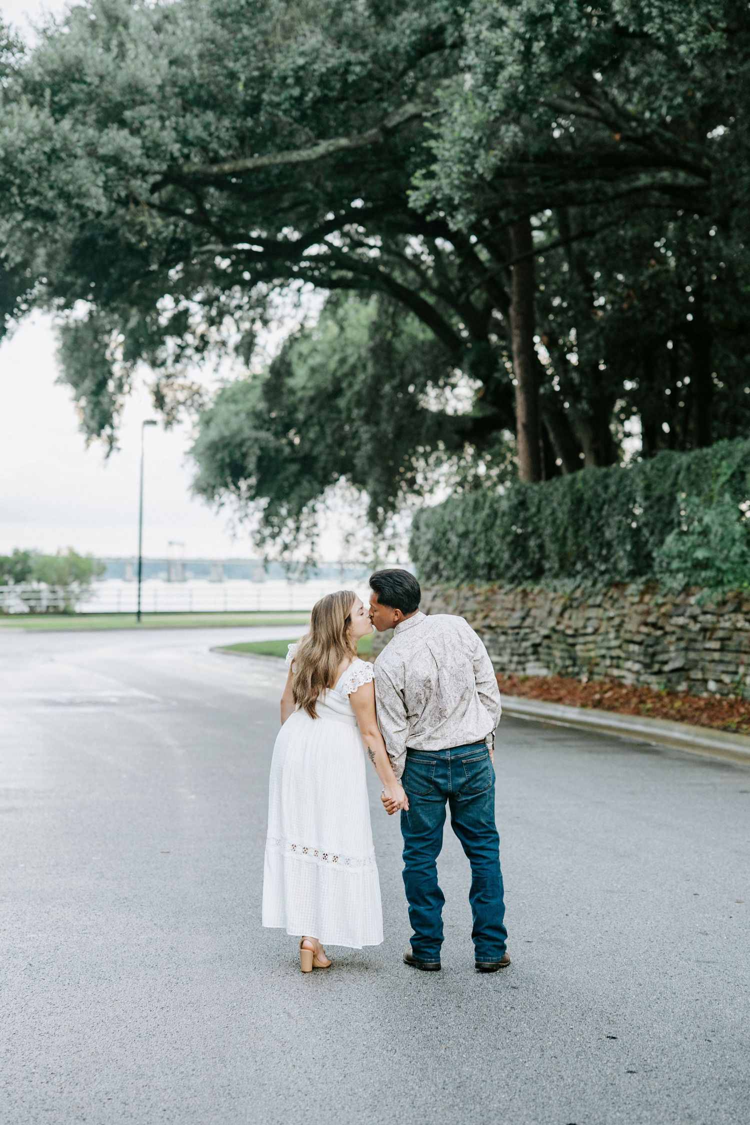 A series of images showing two people walking along a tree-lined path on an overcast day.