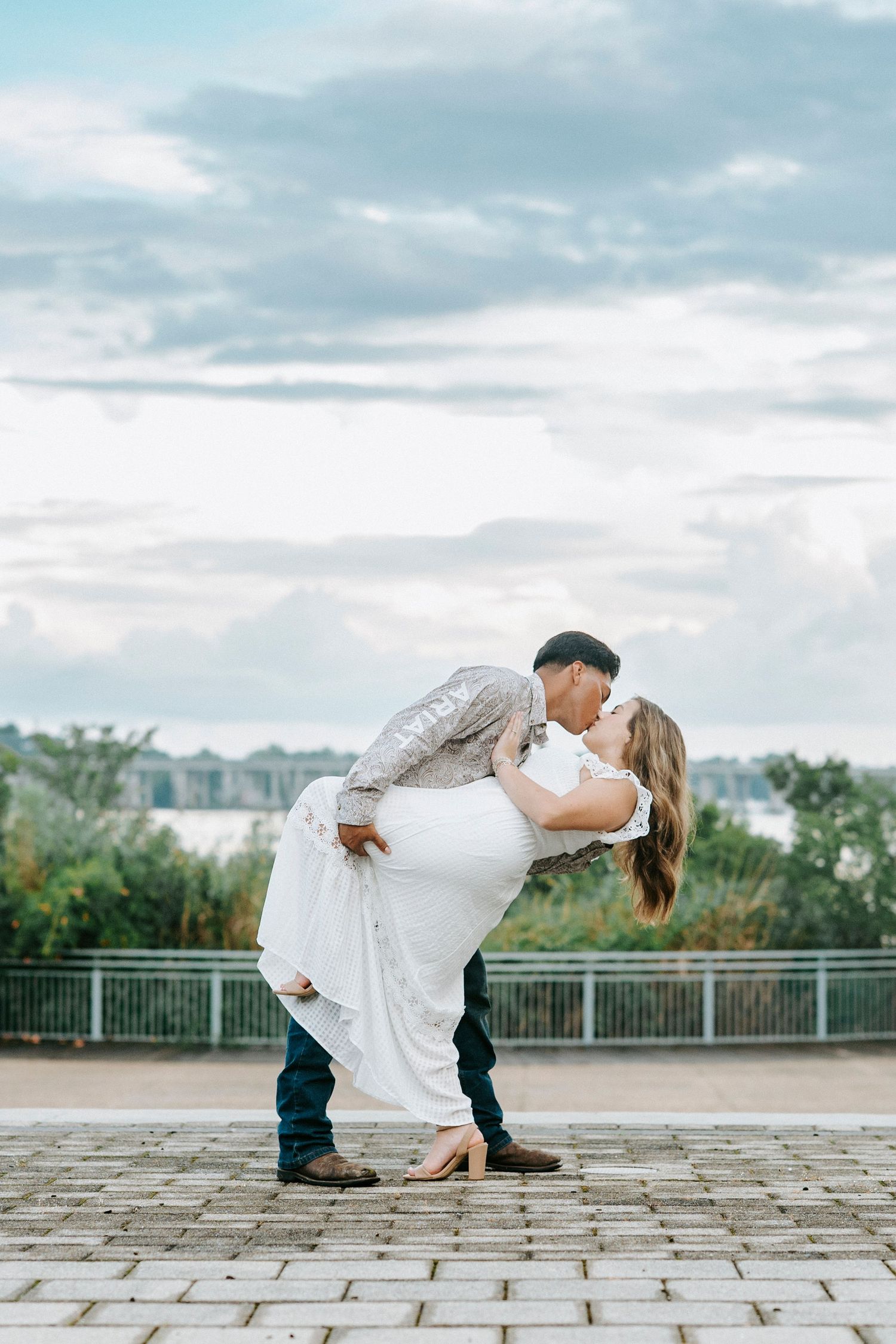 Creative sequence of romantic poses showing couple on stone patio with dramatic cloudy sky backdrop.