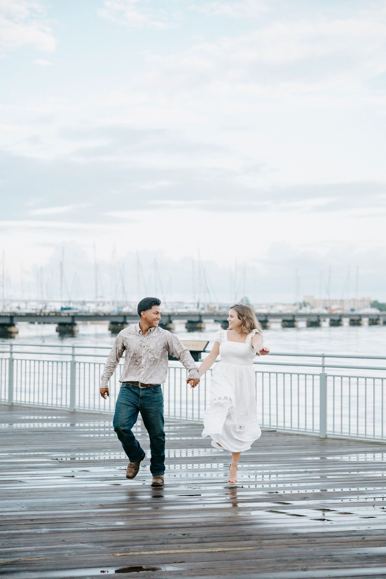 A series of joyful moments captured between a young child and adult running together on a rainy dock by the water.