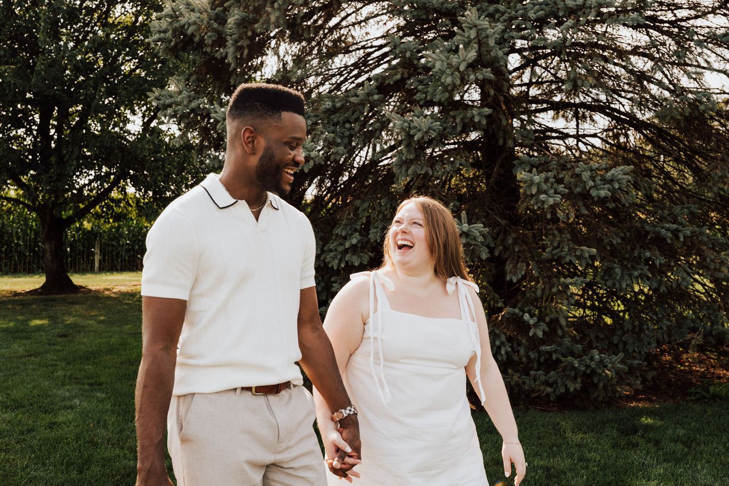 Couple walking in white outfits for Engagement Photoshoot at Waltz Vineyards Estate Winery in Manheim, PA