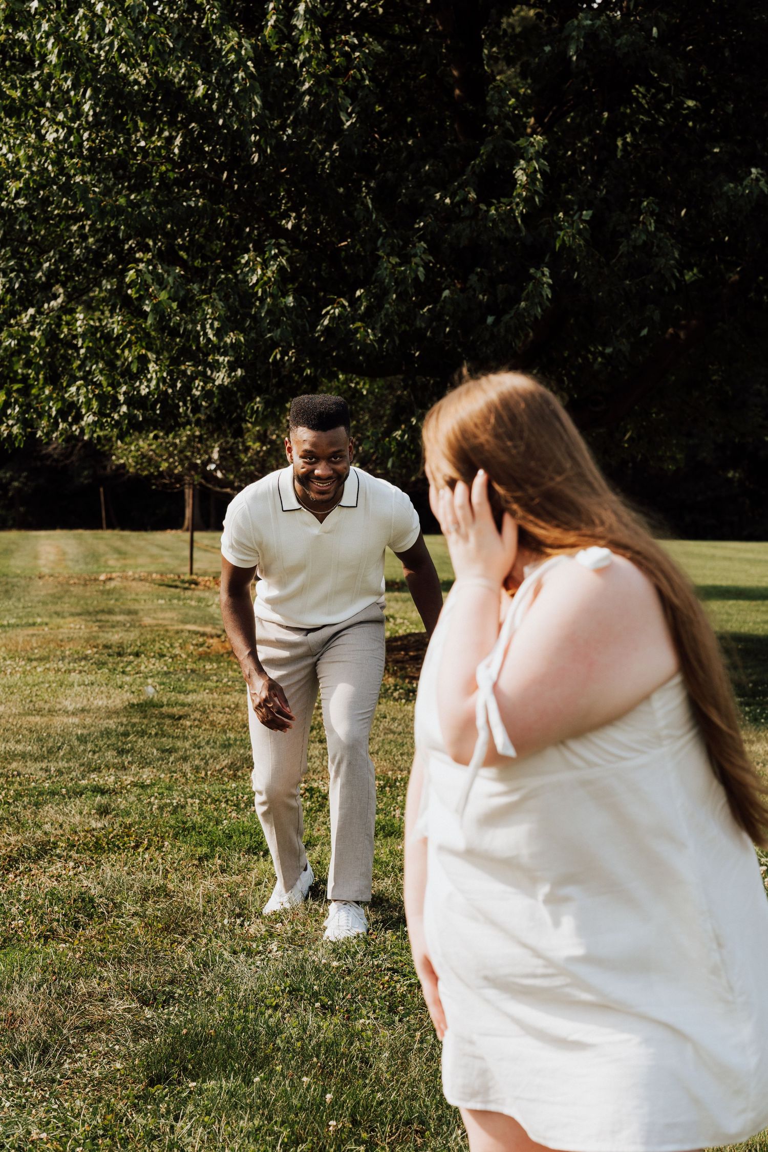 A couple dressed in white having a playful candid moment together for Engagement Photoshoot at Waltz Vineyards Estate Winery